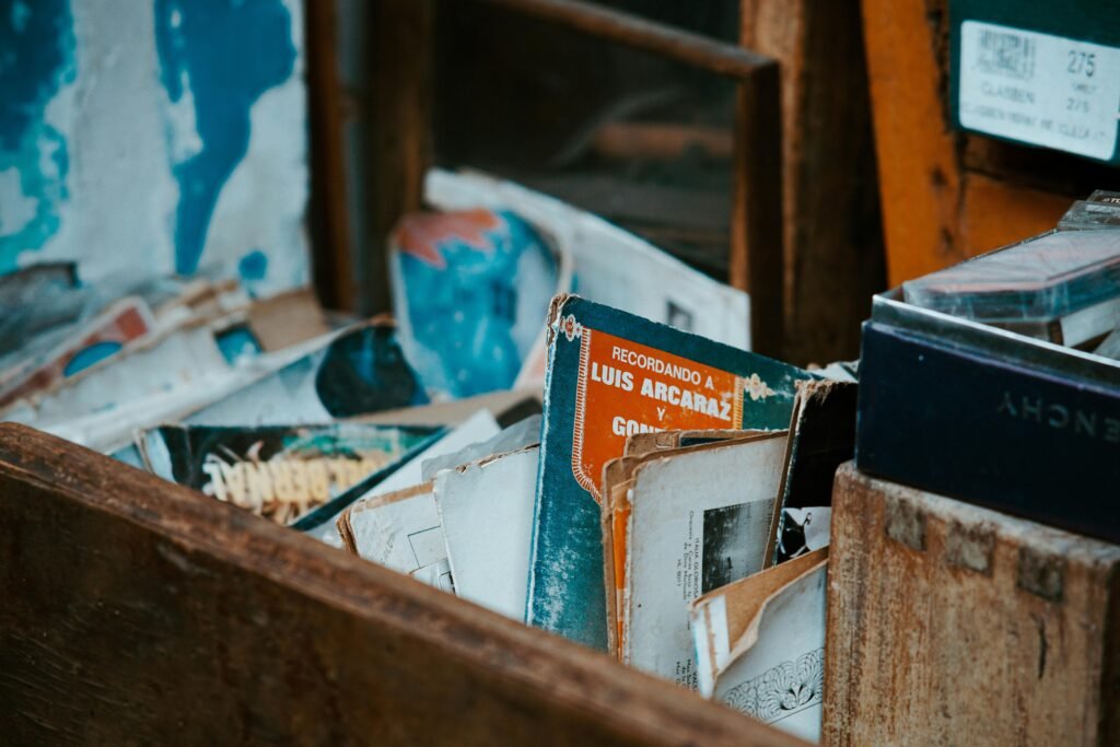 Explore this vintage collection of old vinyl records housed in a rustic wooden box, perfect for nostalgia lovers.